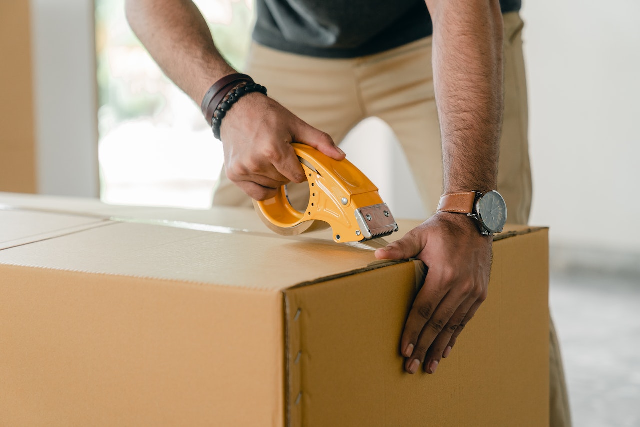 Man taping box: Can I Rent Out My Garage for Storage?